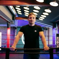 Professional female coach Nina Korolchuk smiling in gym